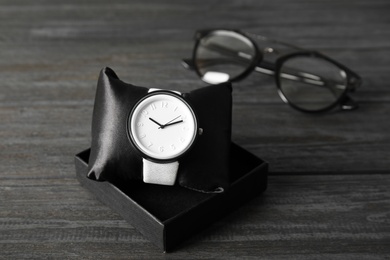 Photo of Composition with stylish wrist watch on wooden background. Fashion accessory