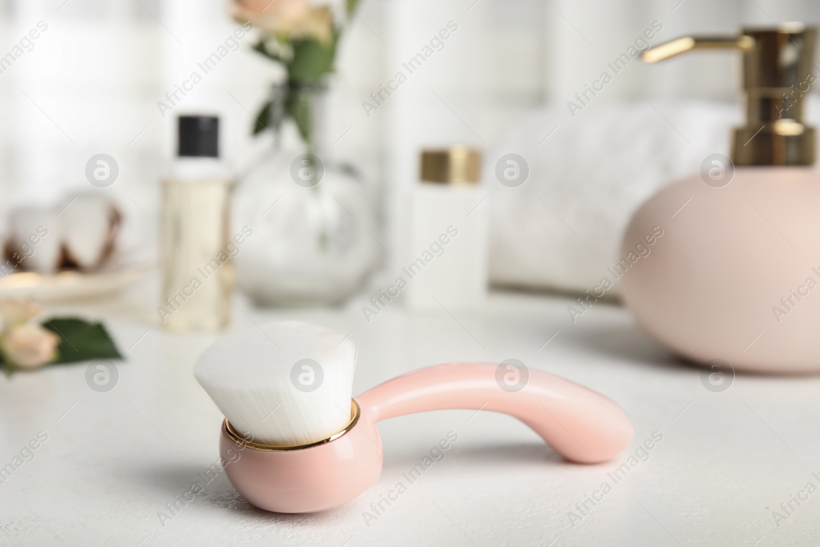 Photo of Stylish face cleansing brush on white table. Cosmetic accessory