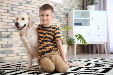 Cute little child with his pet on floor at home