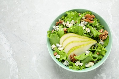 Photo of Tasty salad with pear slices on light grey marble table, top view. Space for text