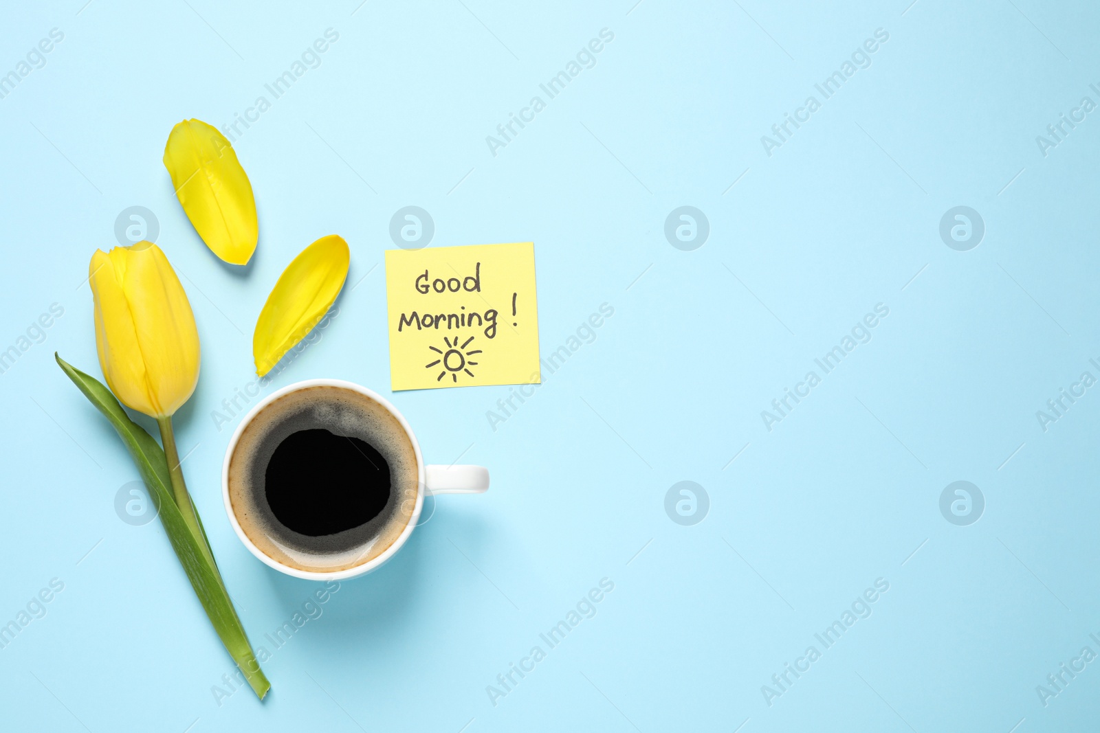 Photo of Delicious coffee, tulip and card with GOOD MORNING wish on light blue background, flat lay. Space for text