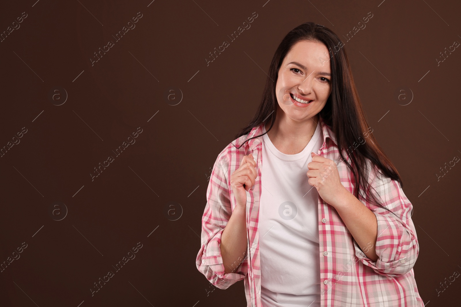 Photo of Beautiful overweight woman with charming smile on brown background. Space for text