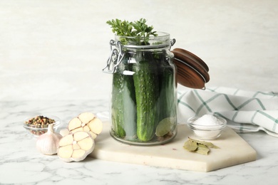 Photo of Pickling jar with fresh ripe cucumbers on white marble table