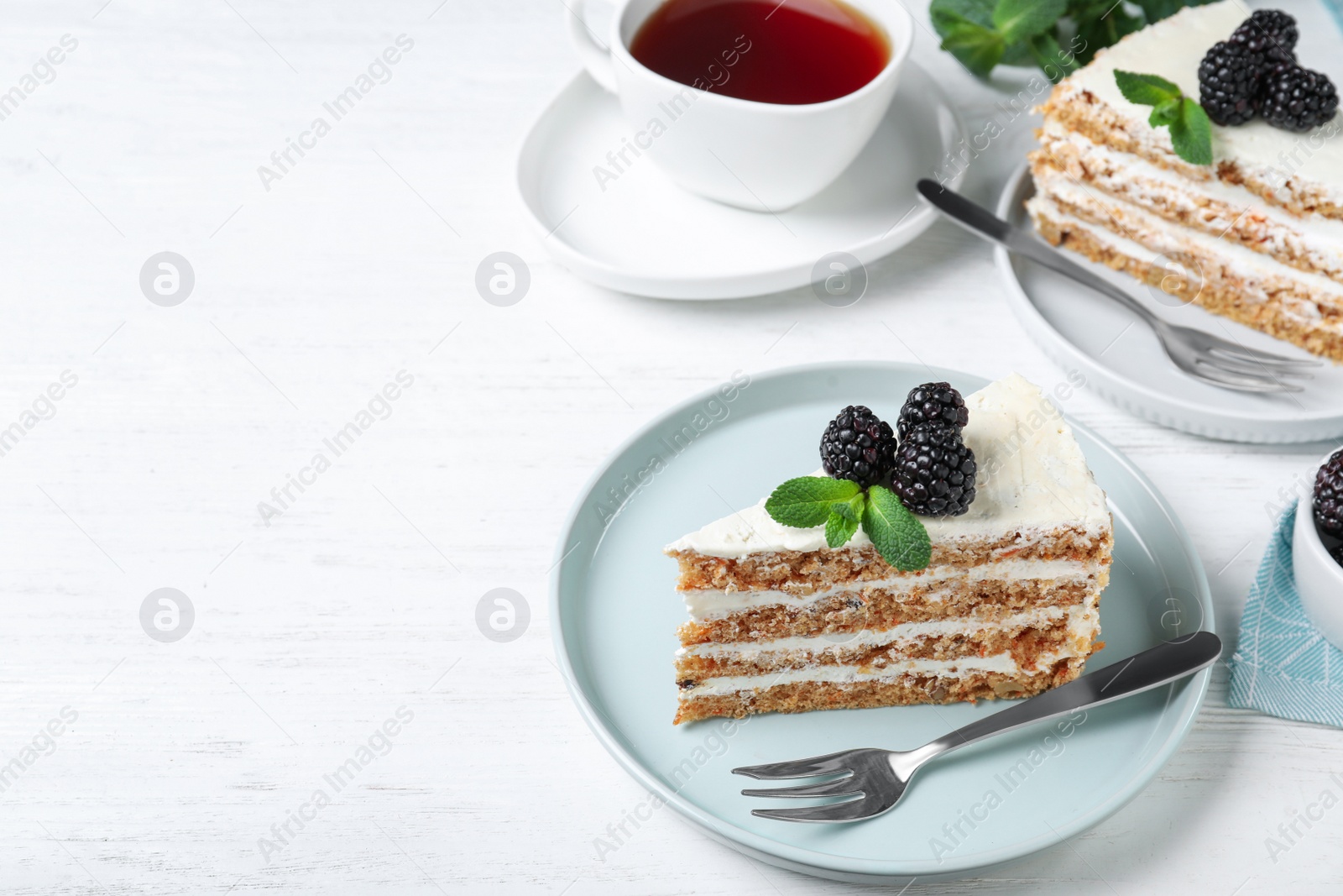 Photo of Tasty cake with berries on white wooden table. Space for text