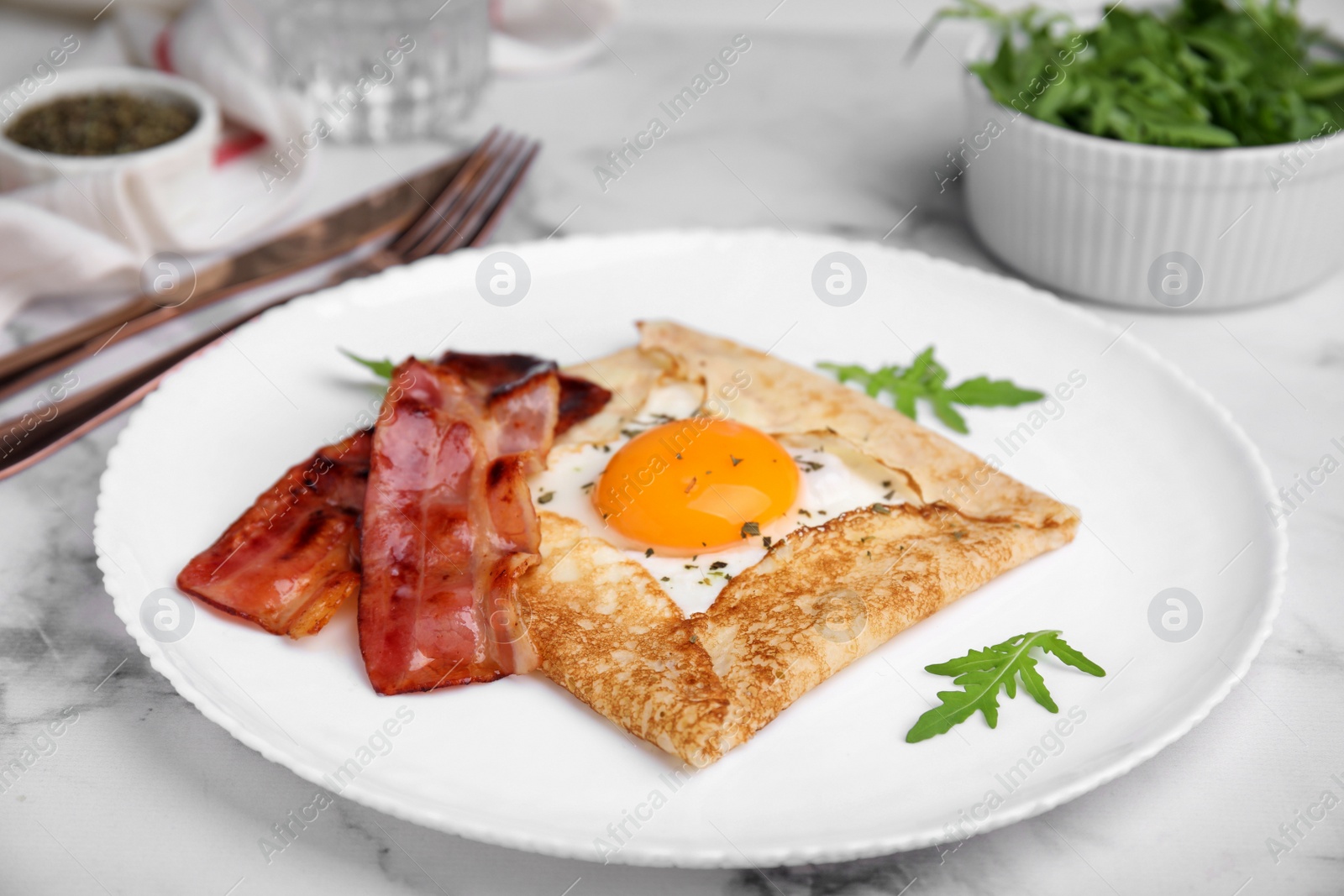 Photo of Delicious crepe with egg served on white marble table. Breton galette