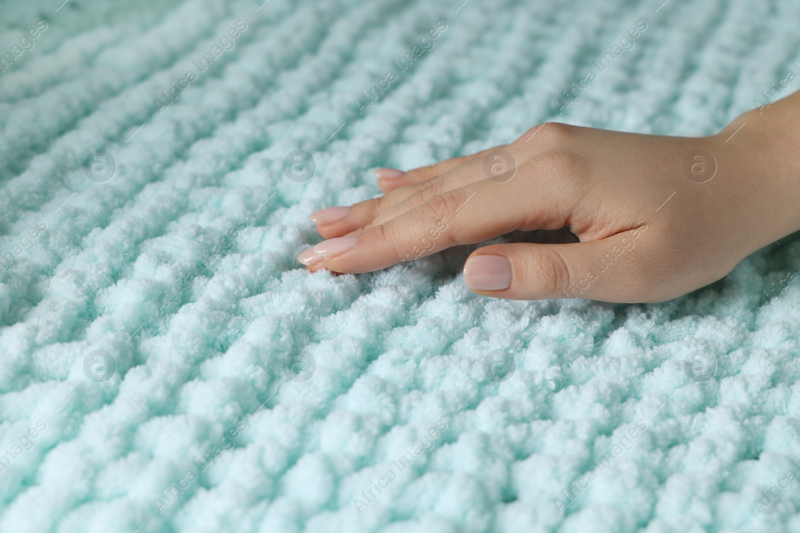 Photo of Woman touching soft turquoise fabric, closeup view