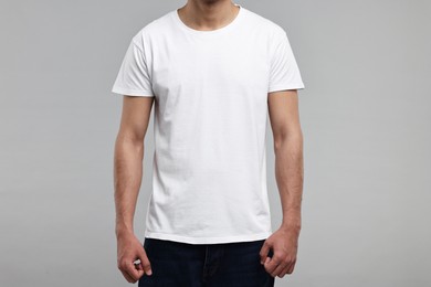 Photo of Man in white t-shirt on grey background, closeup