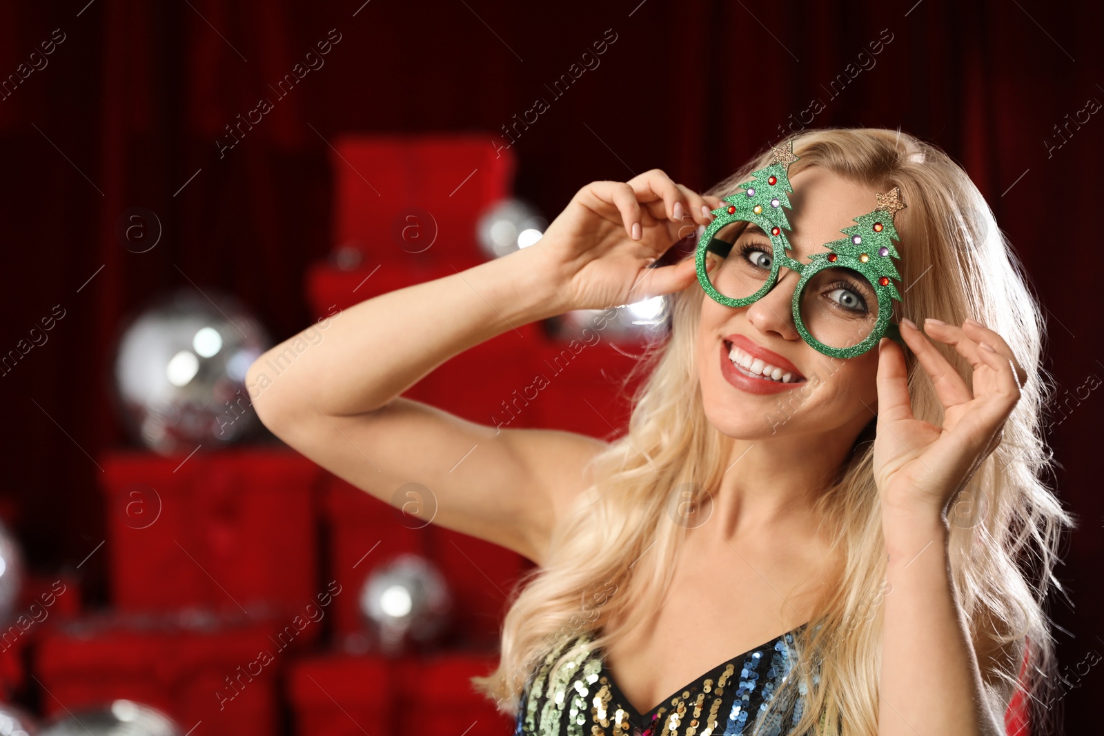 Photo of Happy woman with party glasses indoors. Christmas celebration