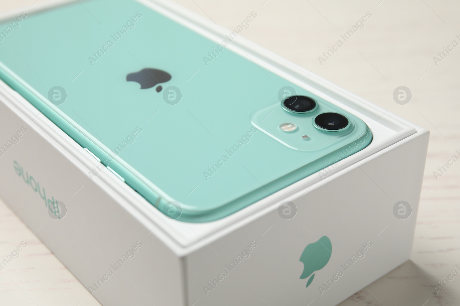 Photo of MYKOLAIV, UKRAINE - JULY 10, 2020: New modern Iphone 11 Green in original box on white table, closeup