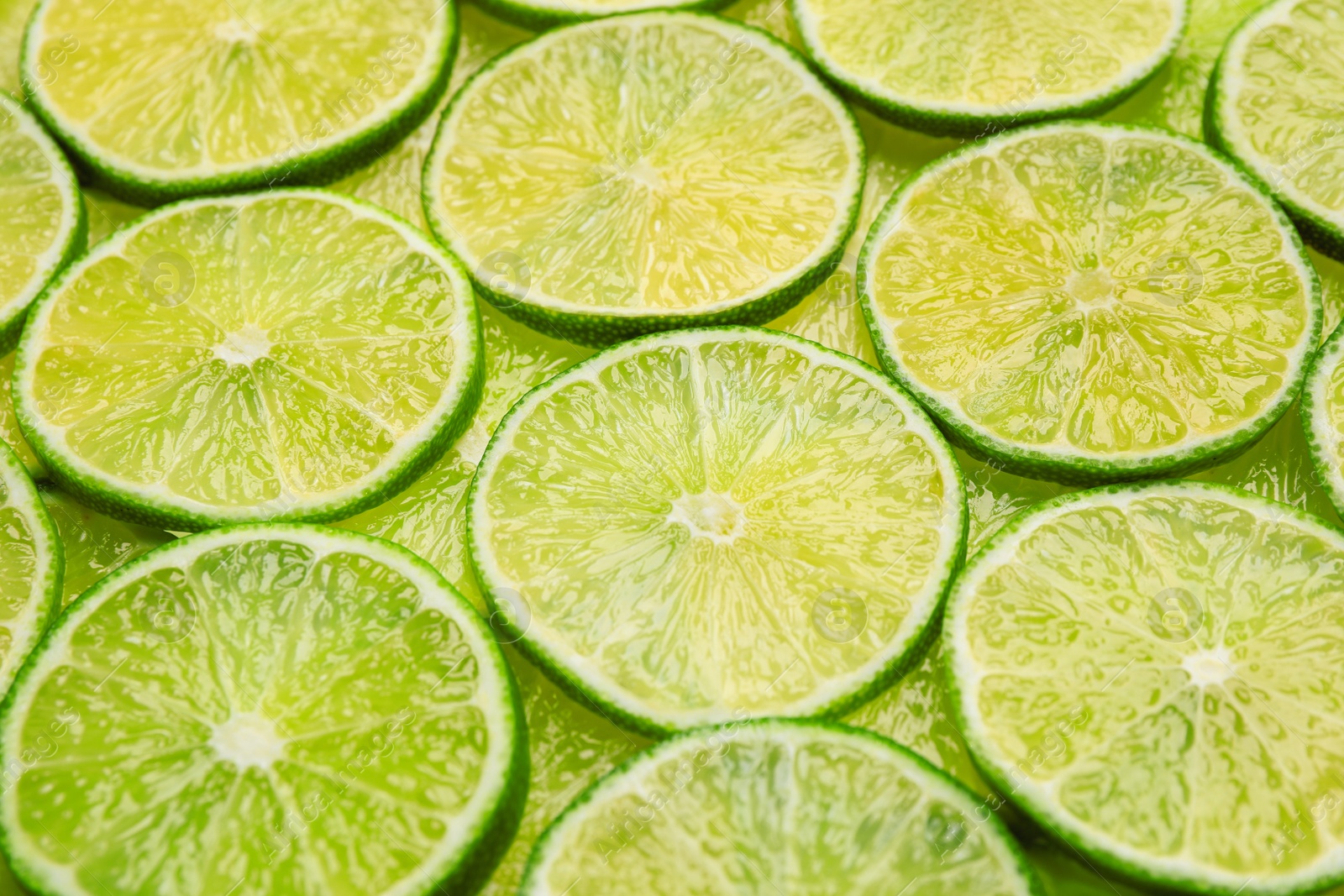 Photo of Many fresh juicy lime slices as background, closeup