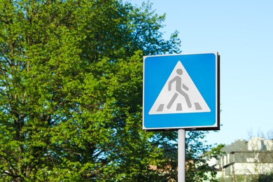 Post with Pedestrian Crossing traffic sign in city on sunny day