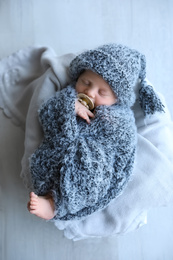 Photo of Cute newborn baby sleeping on plaid, top view