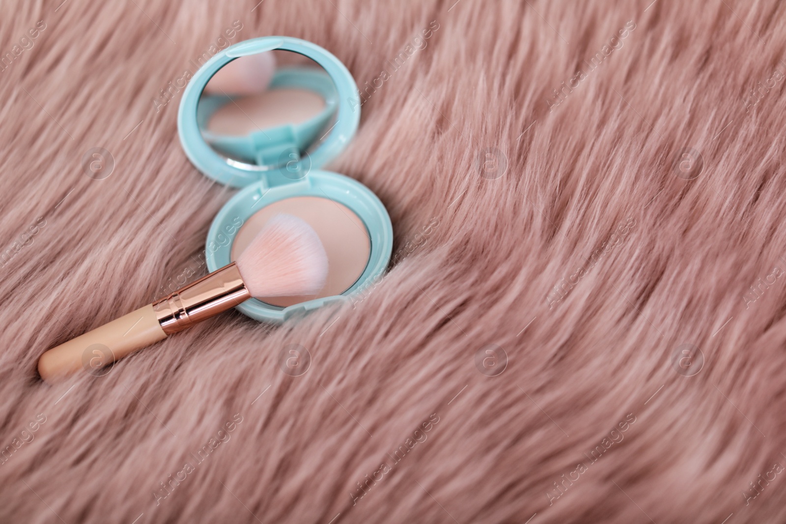 Photo of Makeup brush and powder on faux fur