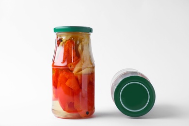 Jars with pickled bell peppers on white background