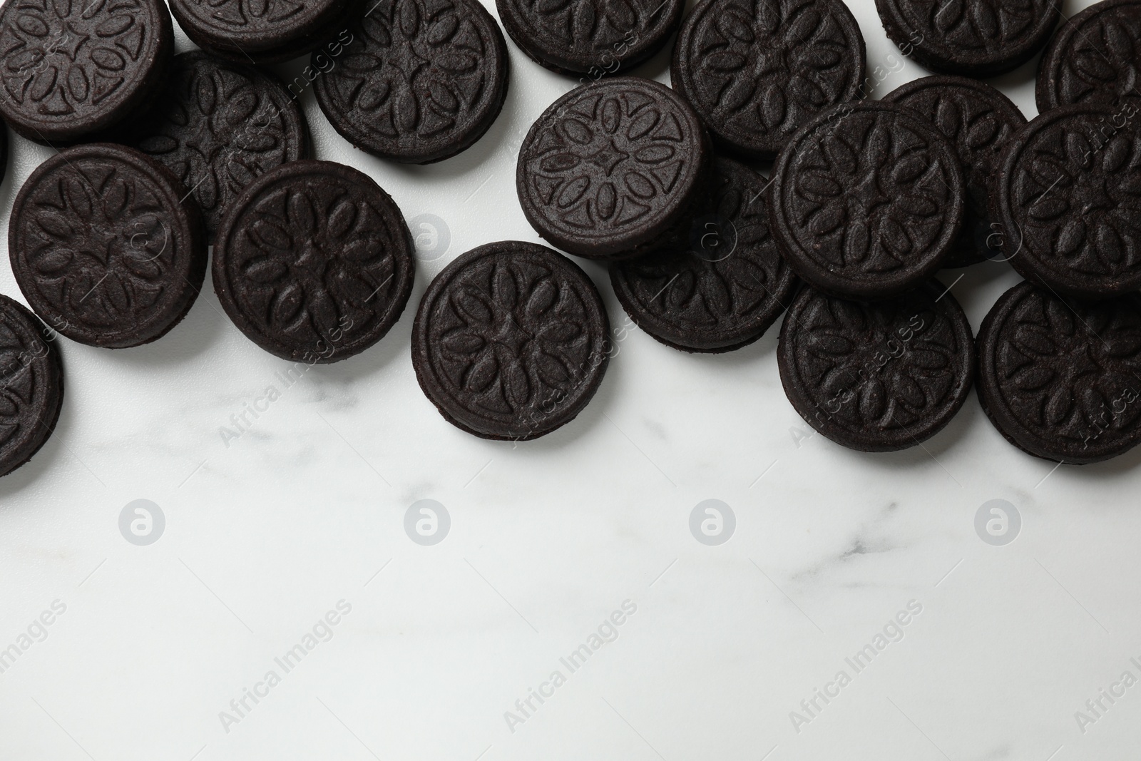 Photo of Tasty sandwich cookies on white marble table, flat lay. Space for text