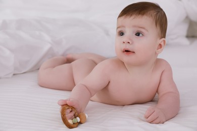 Cute little baby with toy on soft white blanket