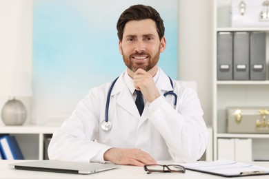 Photo of Medical consultant with stethoscope at table in clinic