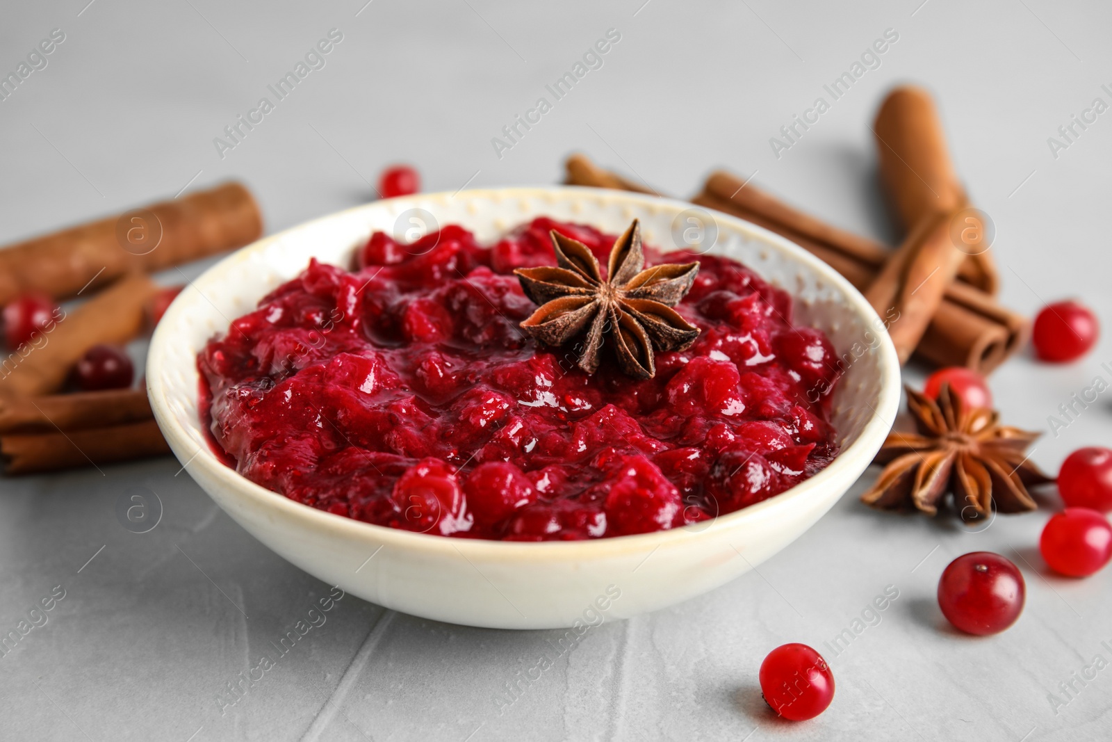 Photo of Plate of cranberry sauce with spices on table