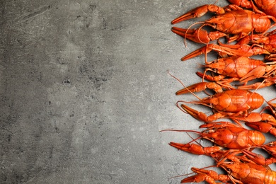 Delicious boiled crayfishes on grey table, flat lay. Space for text