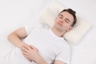 Photo of Man sleeping on orthopedic pillow in bed