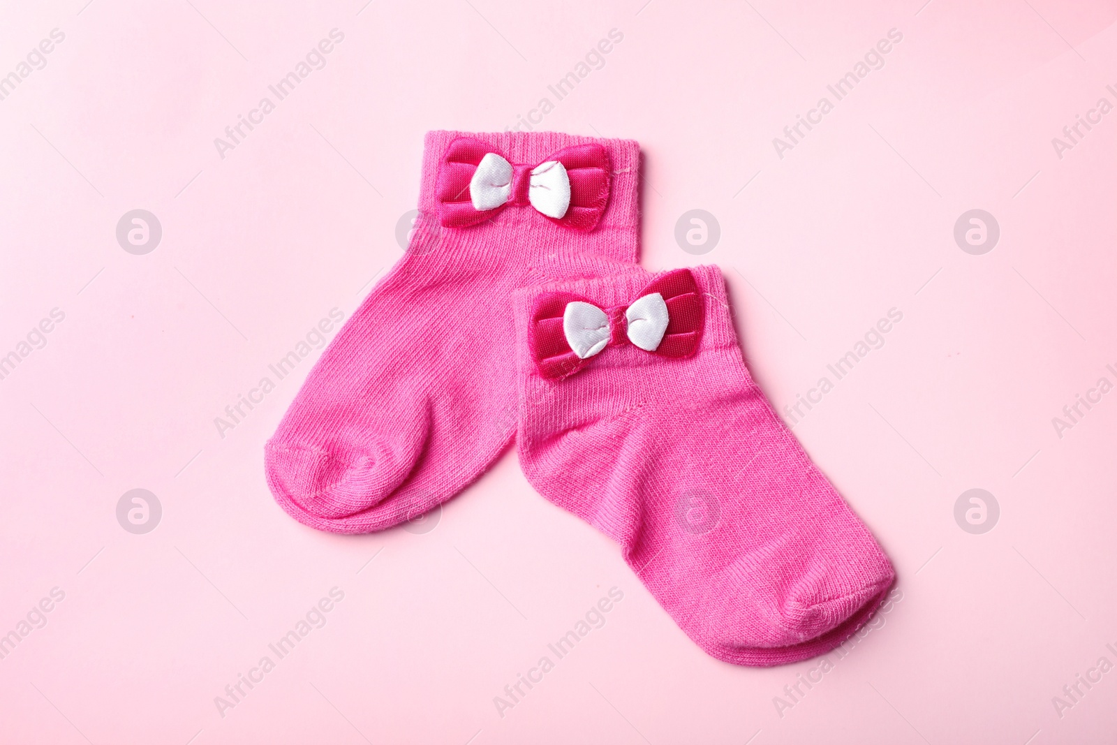Photo of Pair of cute child socks on color background, top view