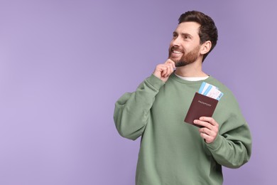 Smiling man with passport and tickets on purple background. Space for text