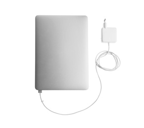 Laptop and charger on white background, top view. Modern technology