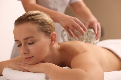 Therapist giving cupping treatment to patient indoors