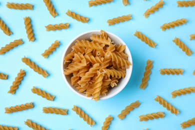 Flat lay composition with wholemeal fusilli pasta on light blue background