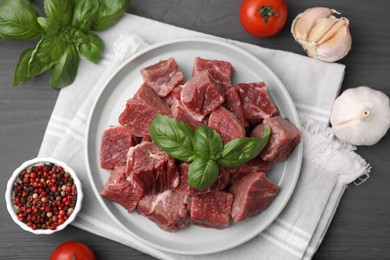 Photo of Flat lay composition with cut fresh beef meat on grey wooden table
