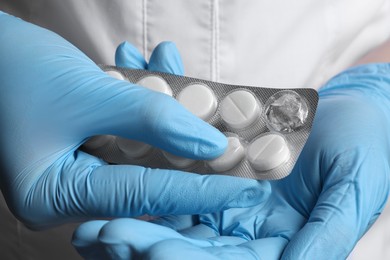 Photo of Doctor taking pill out from blister pack, closeup