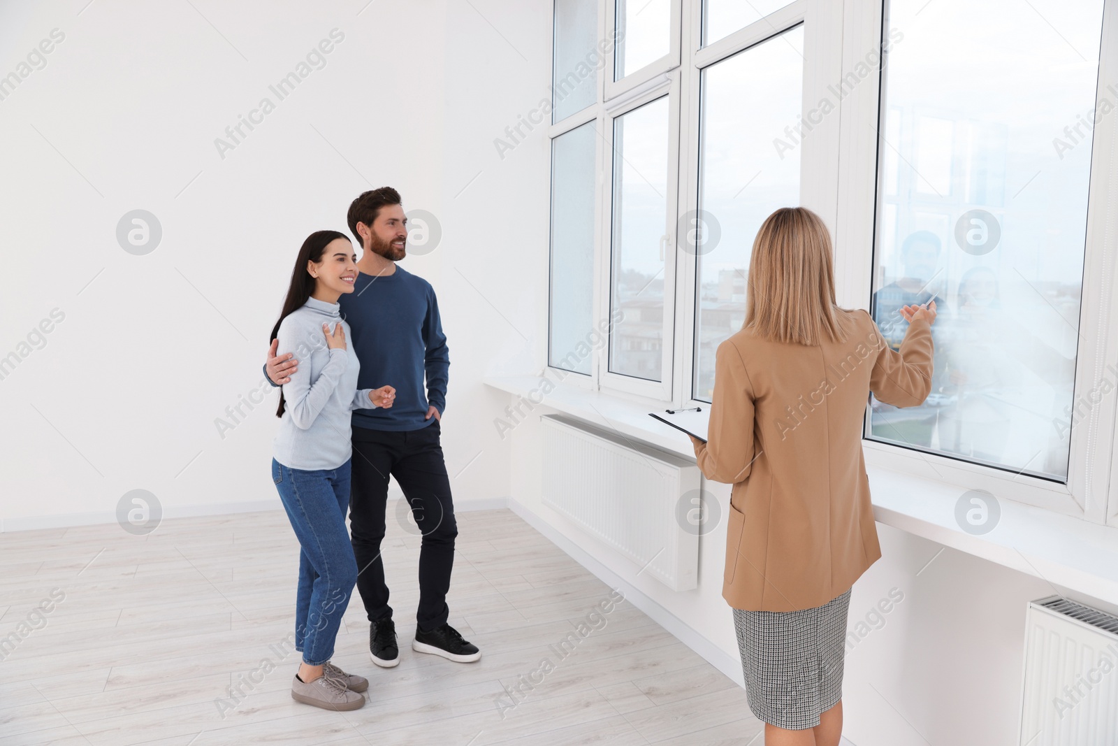 Photo of Real estate agent showing new apartment to couple