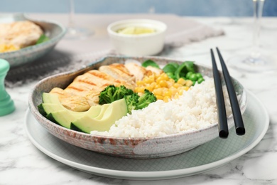 Plate of boiled rice with vegetables and meat on table