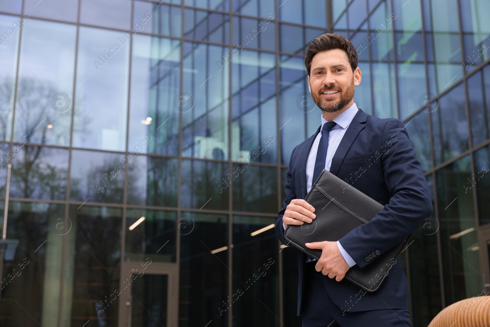 Photo of Real estate agent with leather portfolio outdoors. Space for text