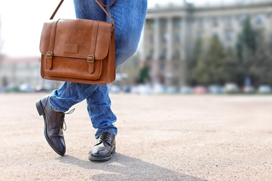 Photo of Man with stylish bag and leather shoes outdoors, closeup