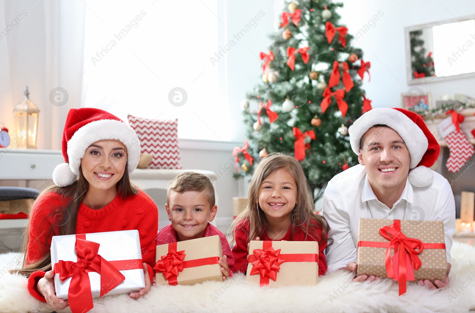 Photo of Happy parents with children and gifts at home. Celebrating Christmas