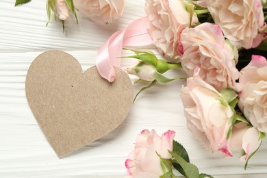 Photo of Happy Mother's Day. Beautiful flowers with blank heart shaped card on white wooden table, closeup