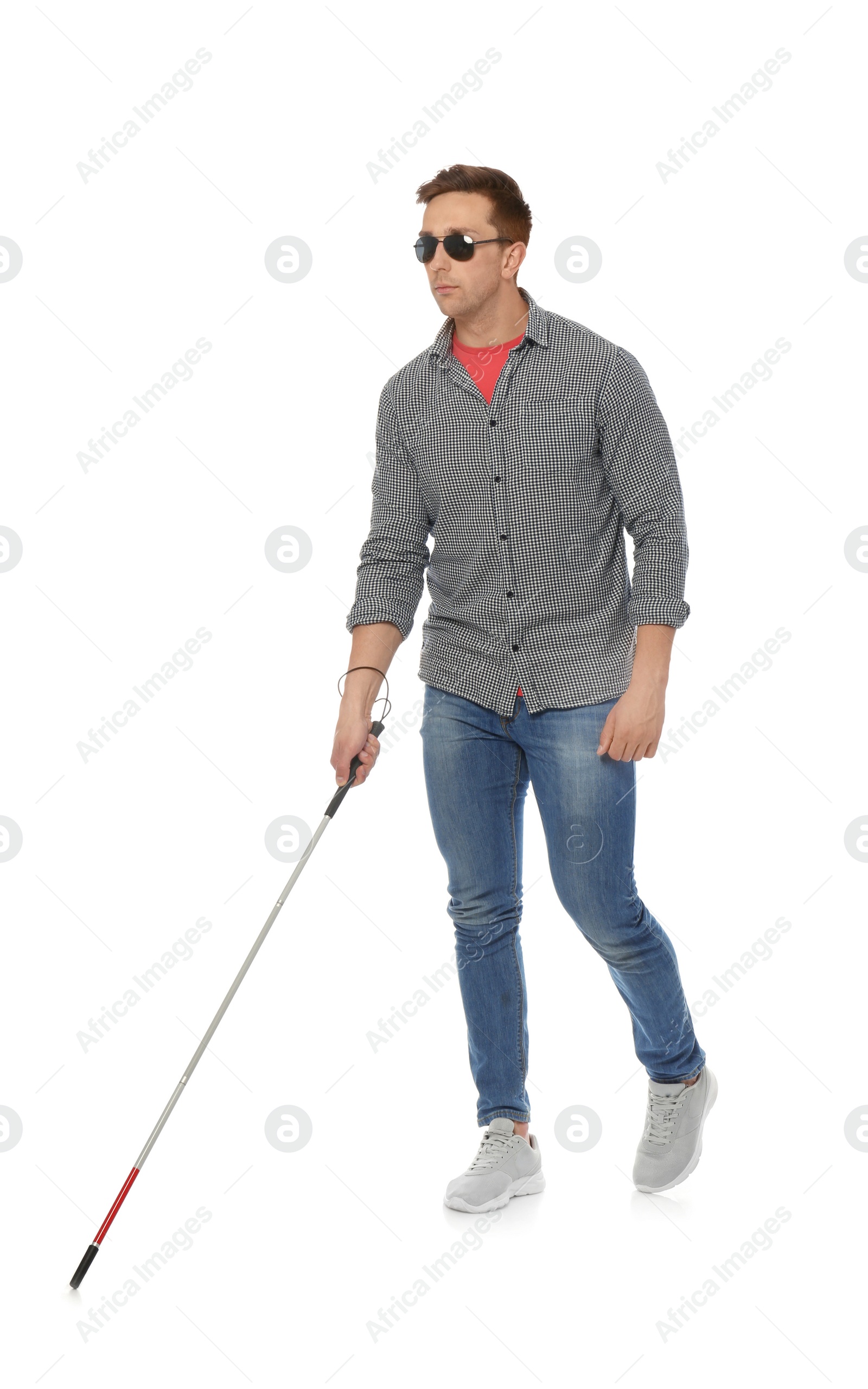 Photo of Young blind person with long cane walking on white background