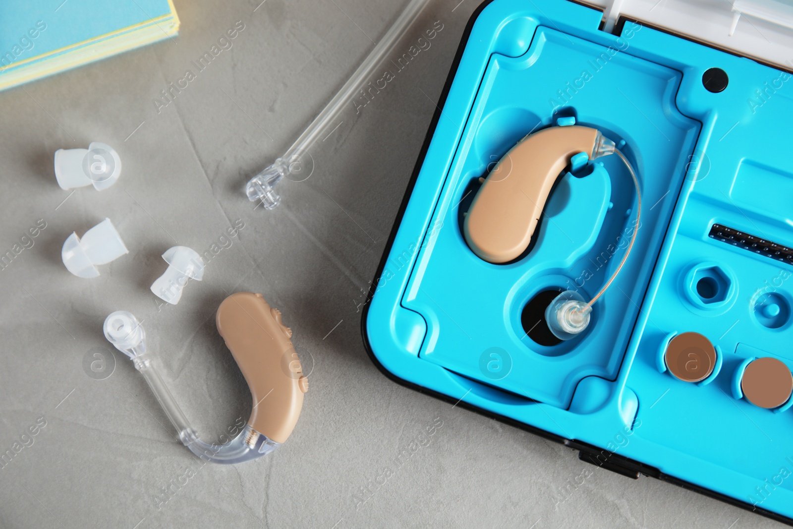 Photo of Hearing aids and case on grey table, top view