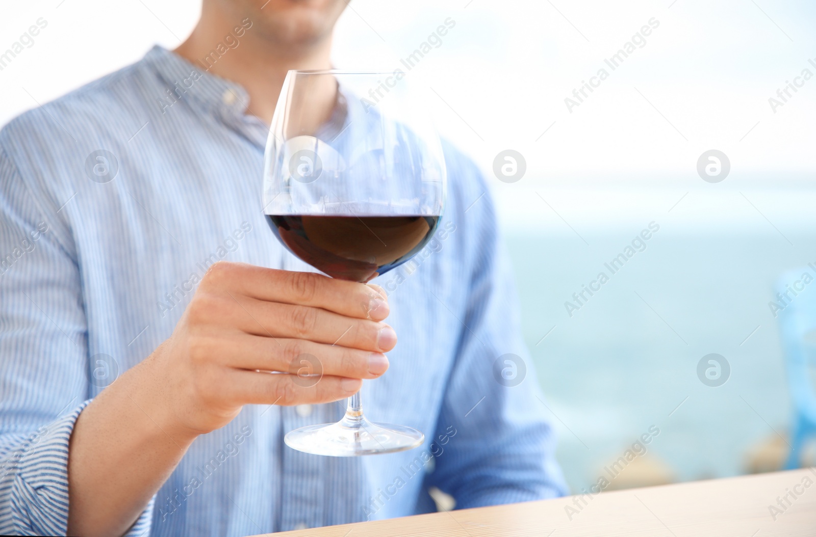 Photo of Young man with glass of red wine outdoors