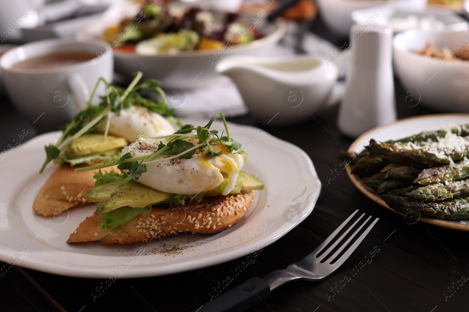 Photo of Delicious sandwiches with eggs and avocado served on buffet table for brunch