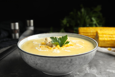 Photo of Delicious corn cream soup served on grey table