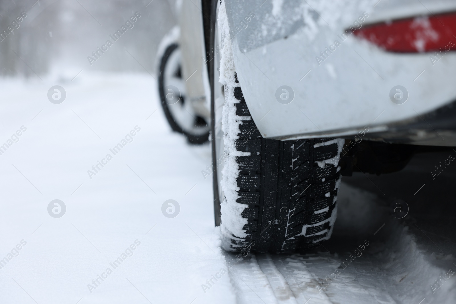 Photo of Car with winter tires on snowy road outdoors, closeup. Space for text