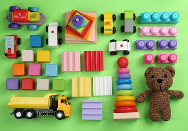 Different children's toys on green background, flat lay