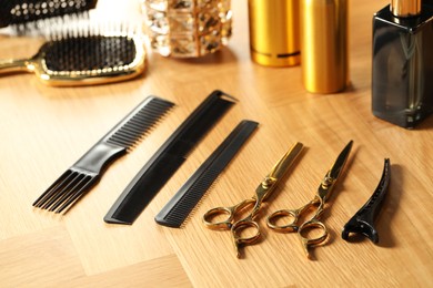 Photo of Hairdresser tools. Different scissors and combs on wooden table, closeup