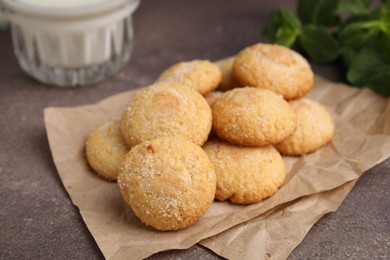 Photo of Tasty sweet sugar cookies, mint and milk on brown table, closeup