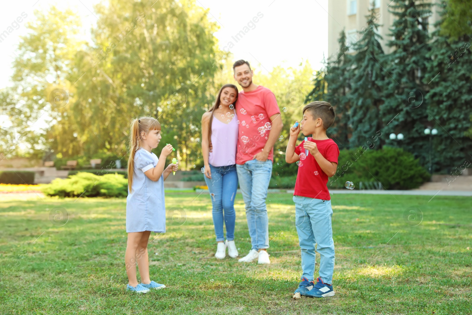 Photo of Happy family with children spending time together in green park on sunny day