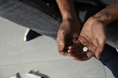 Photo of Young addicted man with drugs, closeup of hands