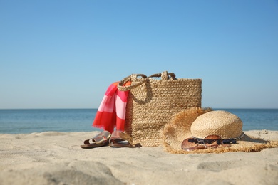 Photo of Stylish beach accessories on sandy sea shore