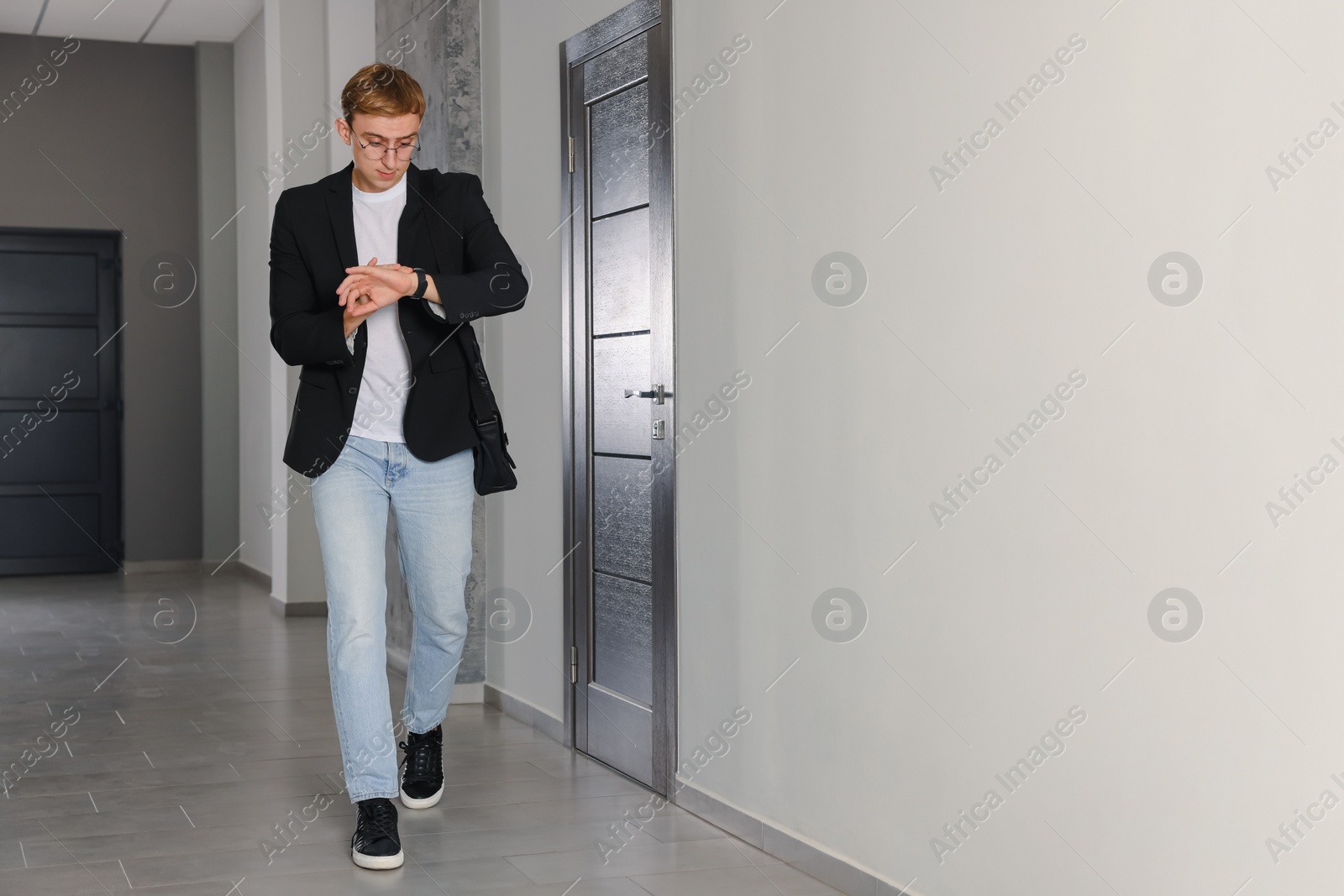 Photo of Emotional man checking time in hall. Being late